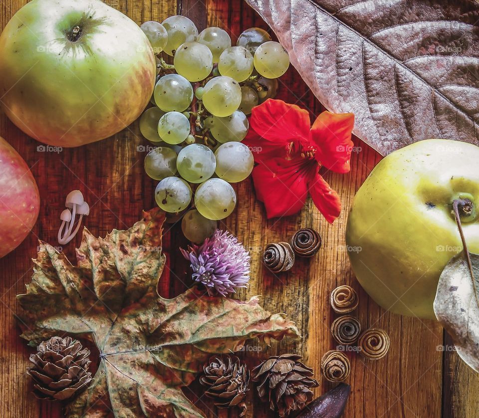 Autumnal fruits and leaves against a wood background 