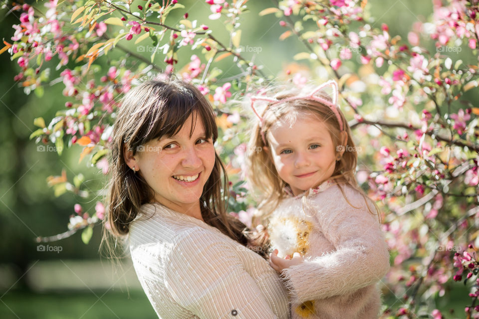 Cute Little girl with mother in a blossom park