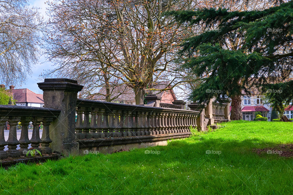 Old stone wall in village commons, communal area for all village residents. UK.