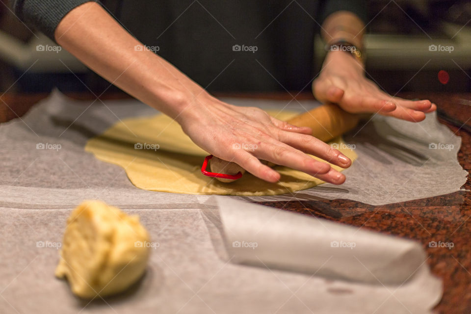 Woman rolling bread dough with rolling pin