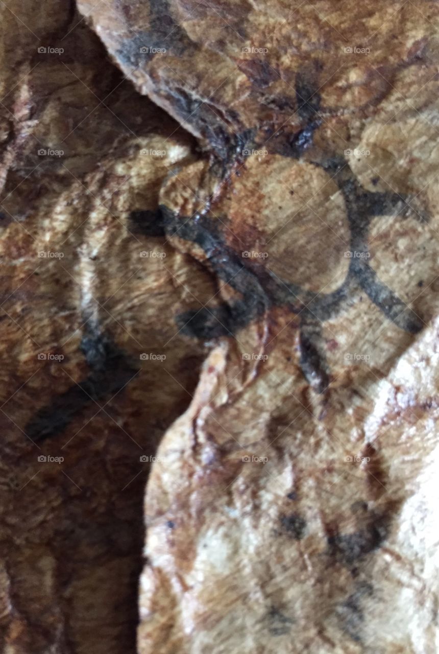 Brown texture Sun. Close up of a primitive drawing of the sun