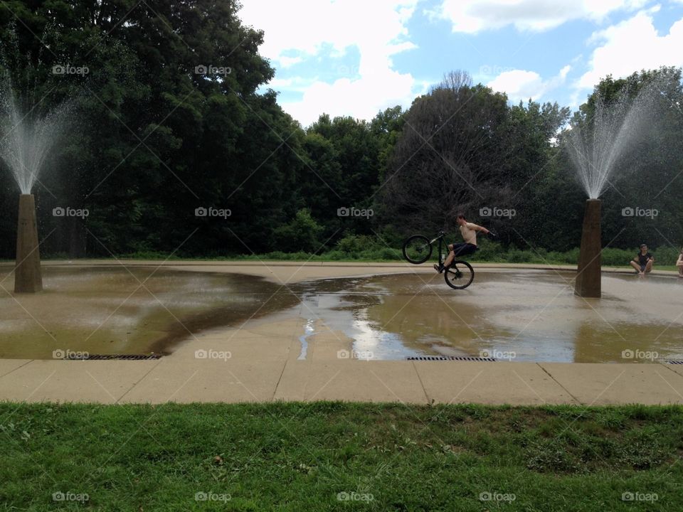 Hot summer ride . Cooling off in fountain mid mountain bike ride 