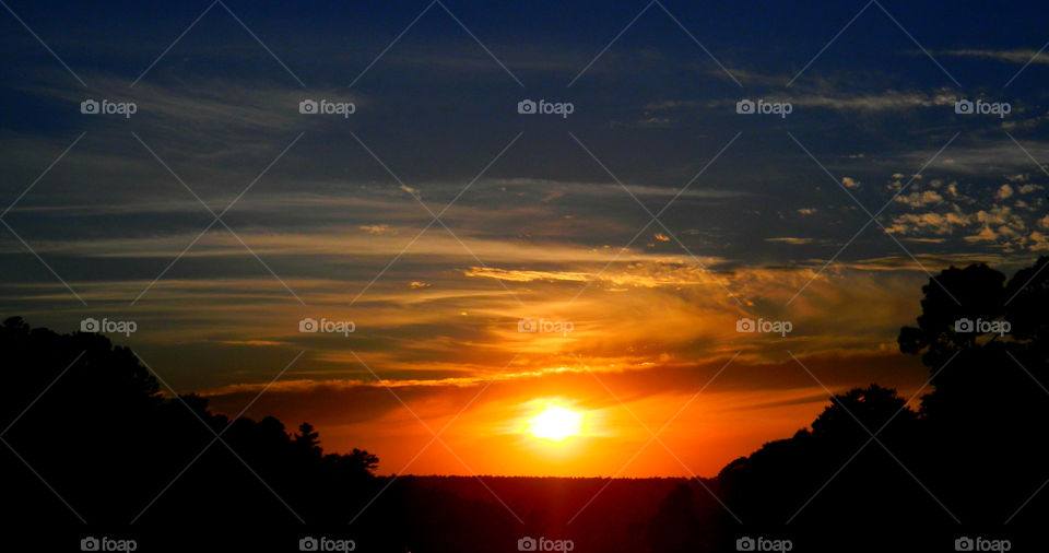 Dramatic sky during sunset with silhouetted trees