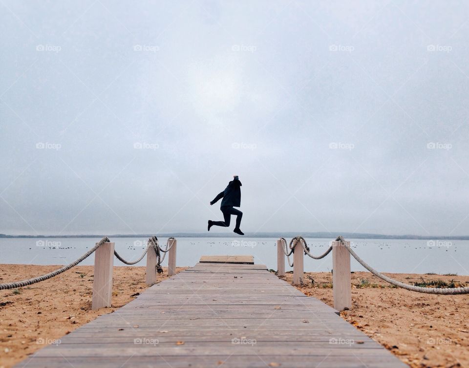 Person jumping near the sea