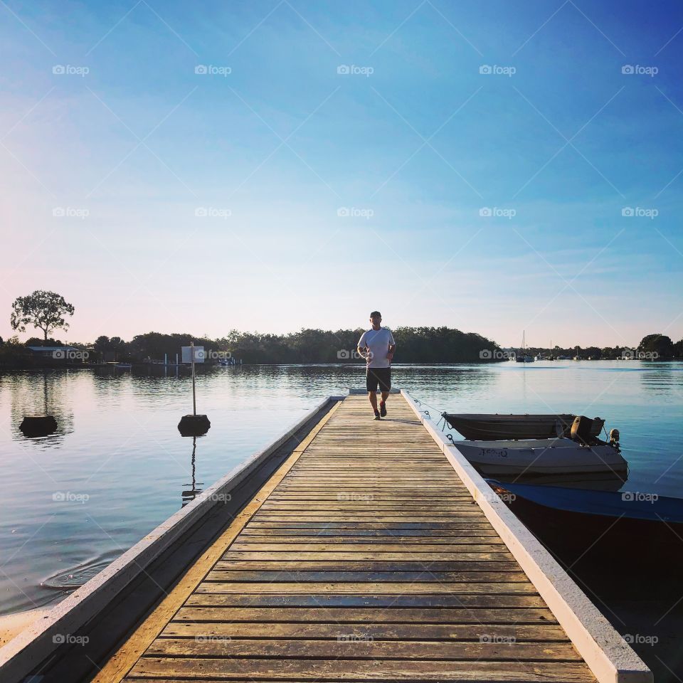 The jetty on the water with a runner