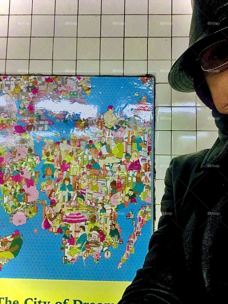 Here I am, „Petra Schiller“ a.k.a. „Maxine Firefox“ only partially visible on the right wearing my black leather outfit with ski mask and hat standing in the „Van Alst Av 21st St „G“ train station in LIC, Queens. 2020. Hypnotic Productions