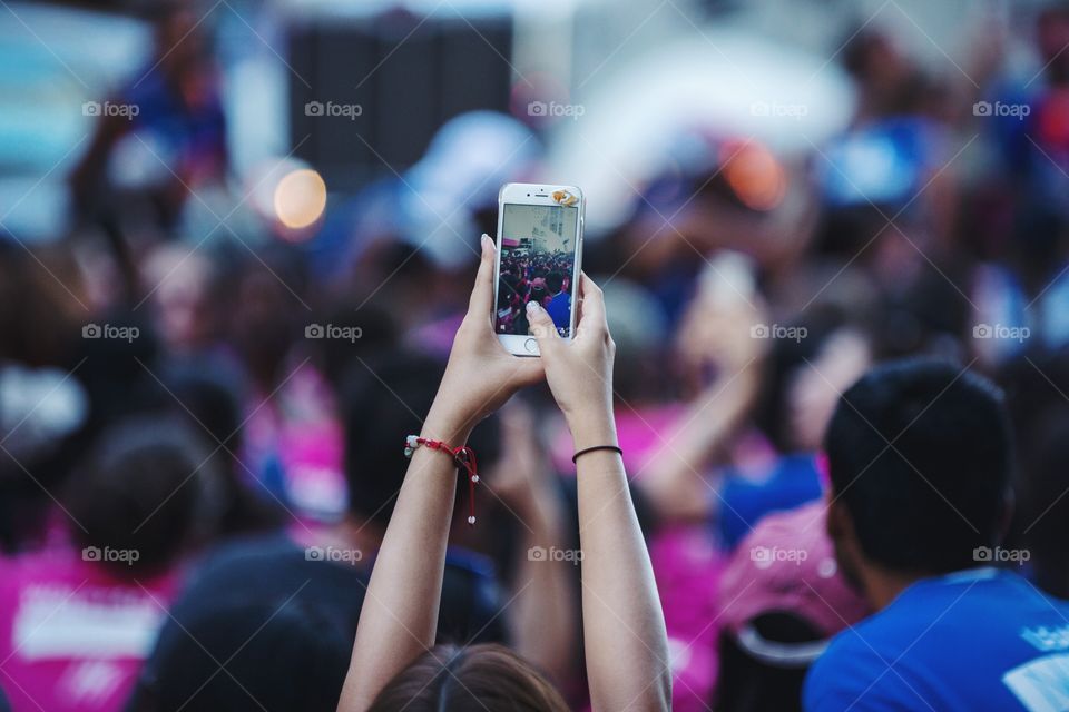 A girl taking a photo outdoors of people