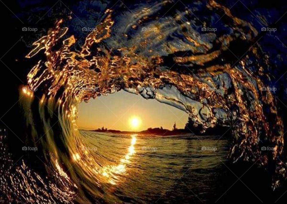 Sunset through a sea wave