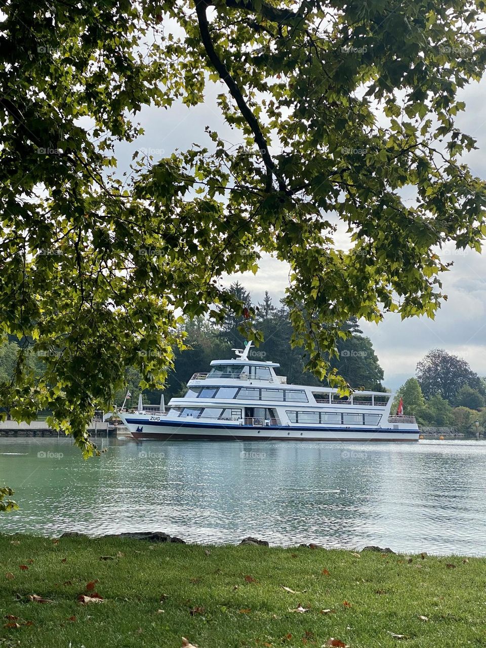 beautiful Swiss landscapes of a Swiss lake with the Alps and a ship on the water.  autumn is coming