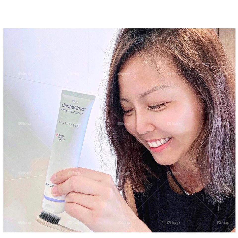 Asian woman with Swiss brand toothpaste 
