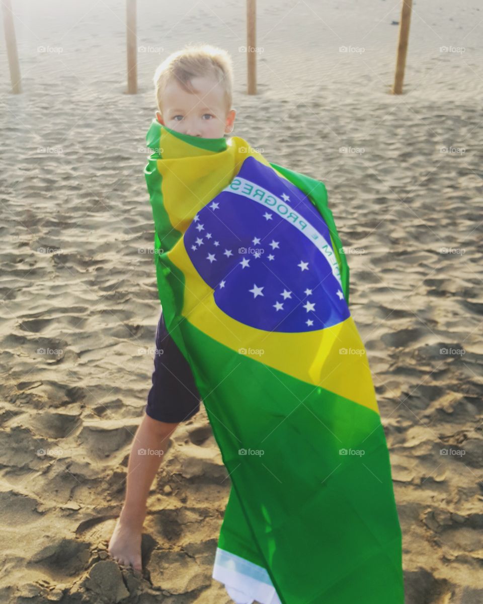 Cute boy wrapped in Brazilian flag