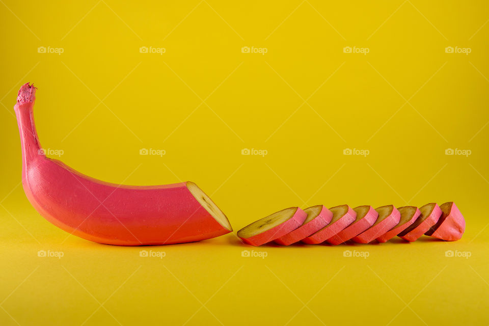 Abstrac pink banana on yellow ba kground. Colorful food concept