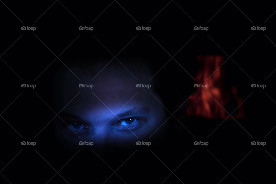 A fun spooky blue and orange edit of a man’s evil eyes with fire (fireplace) behind him. 