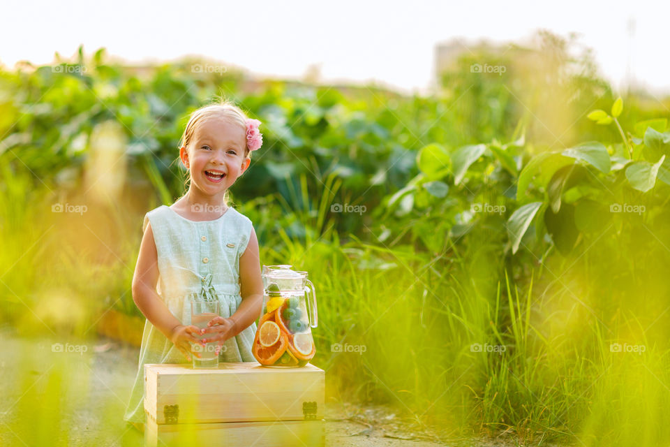Happy little girl and homemade lemonade outdoor 