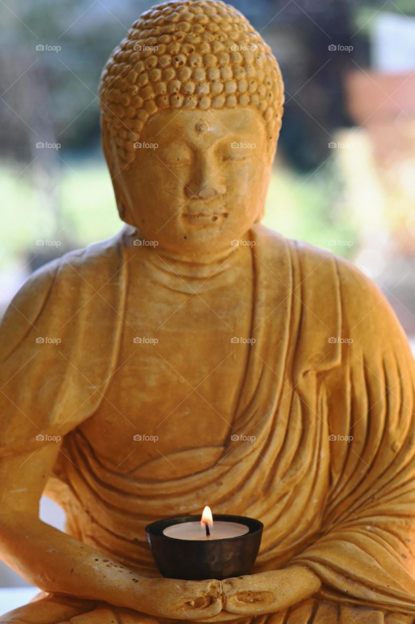 Buddha, sitting Buddha, Yellow Boeddha, Buddha with burning tealight, garden buddha in our house