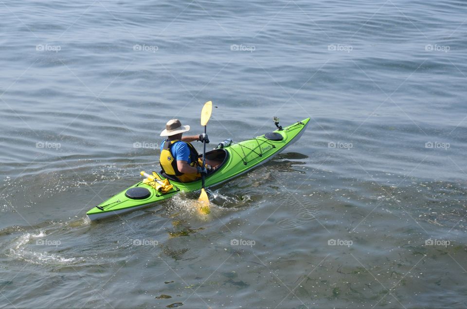 Kayaker paddles off into a kayaking competition in the Puget sound of West Seattle, Washington.