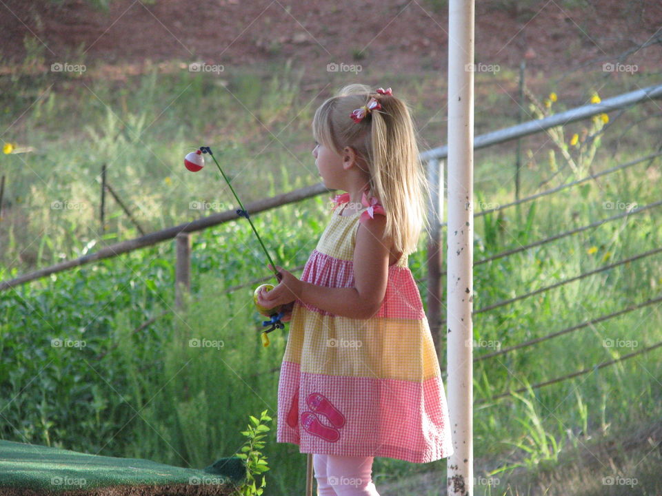 Fishing time. Girl fishing at a tank