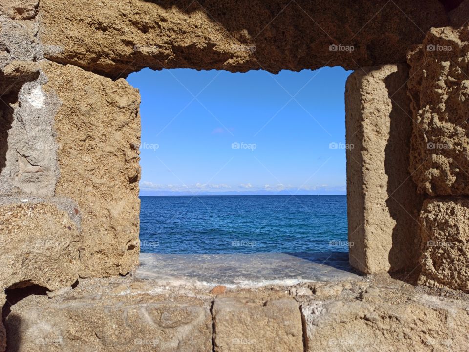 A seascape view through the ancient wall's gap