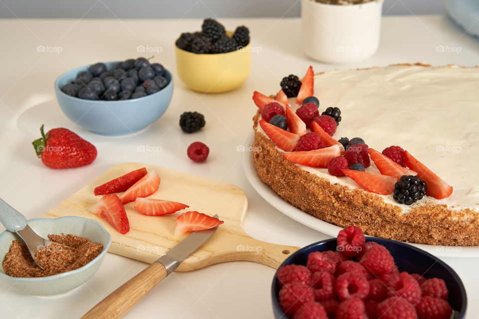 Decorating homemade cake with fresh fruit 