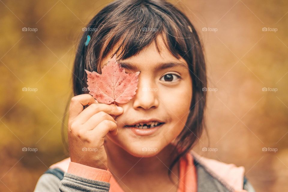 Cute girl with a colourful leaf