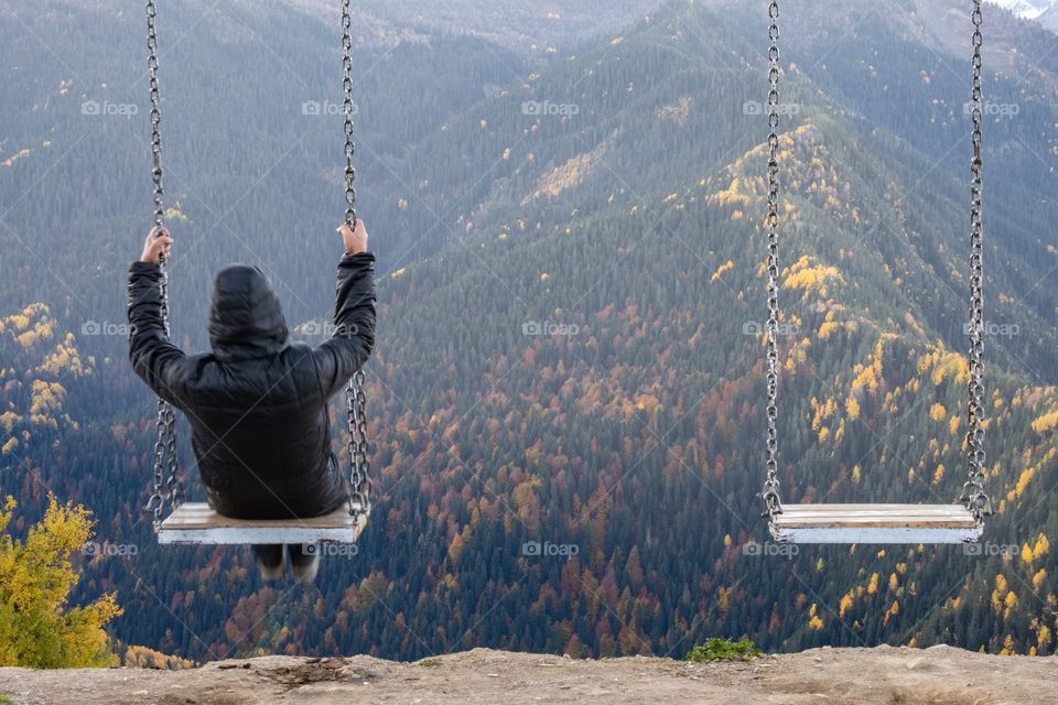 Traveler ‘s playing swing to look beautiful mountain scape in Georgia autumn season