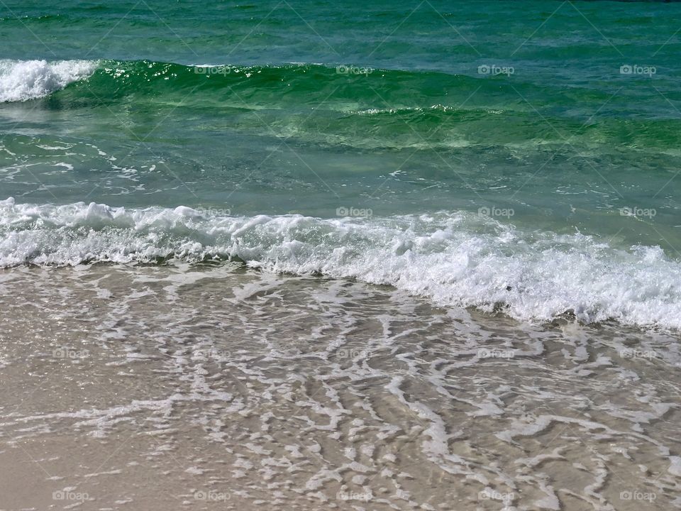 White foam as green waves wash ashore at the Gulf of Mexico 