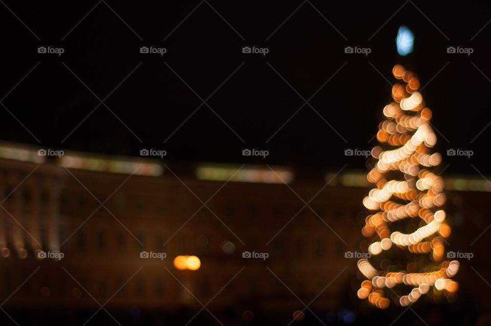 Bokeh silhouette of Christmas tree on the street. New Year. Christmas decorations. Background 