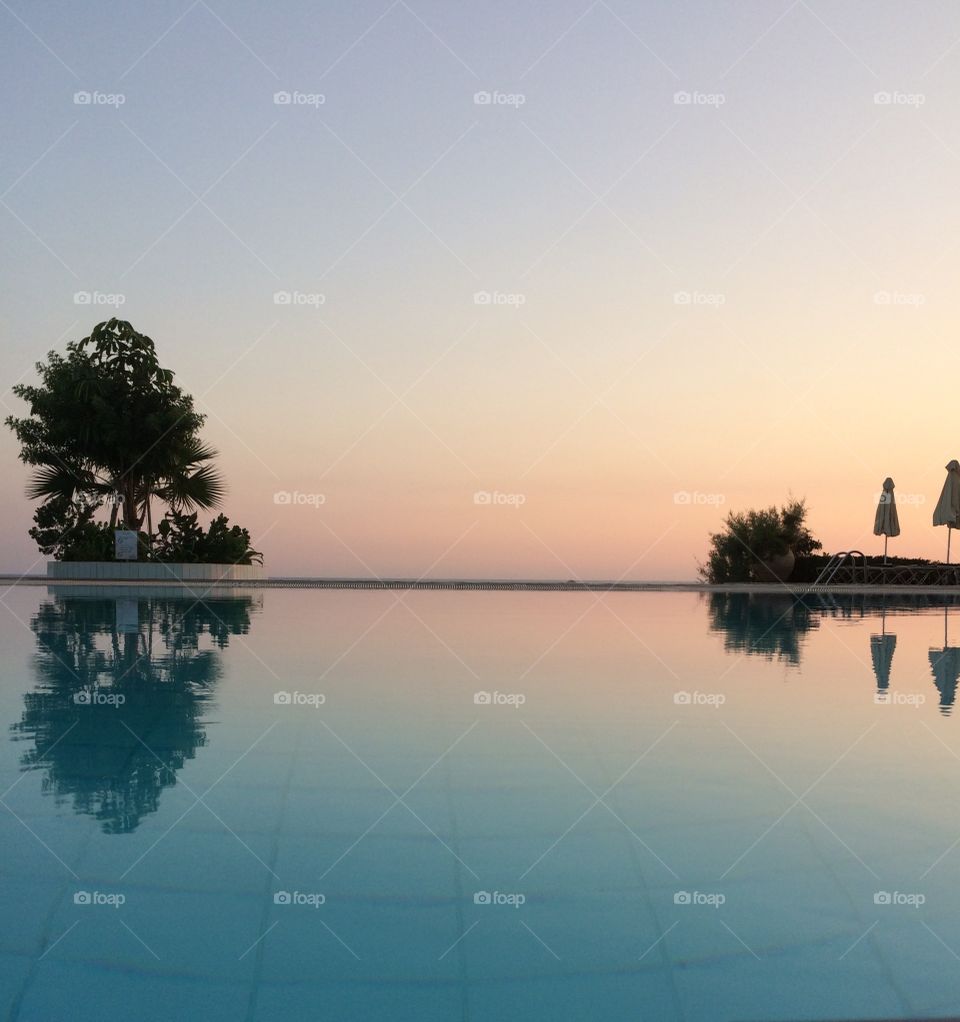 The water edge in sunset, where the pool meets the sea horizon. Ayia Napa, Cyprus