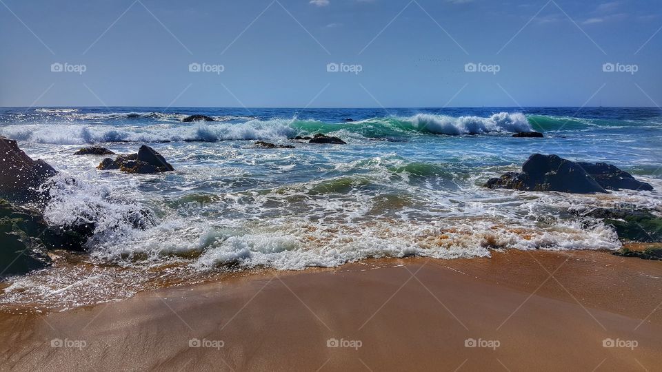 Waves of Pacific Ocean crashing against the shore of Rañaca in Chile