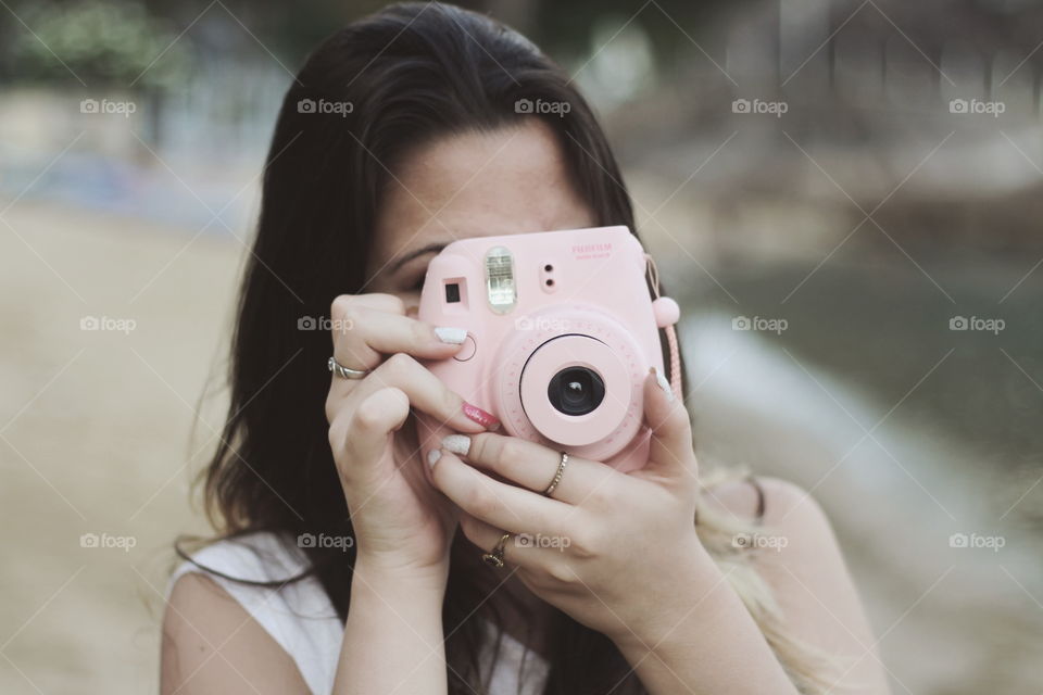 Girl taking a picture using a Polaroid camera