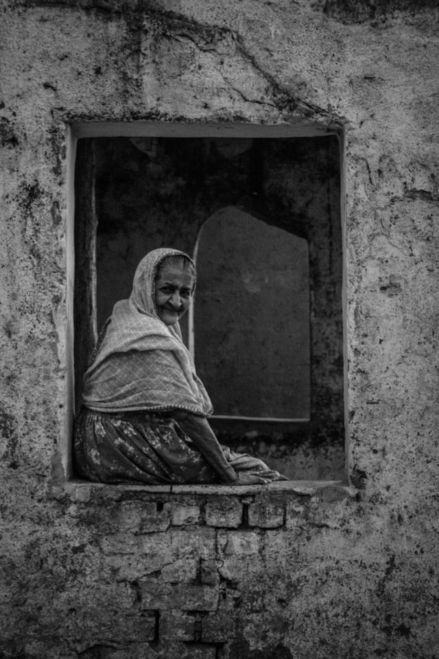 Senior woman sitting on window
