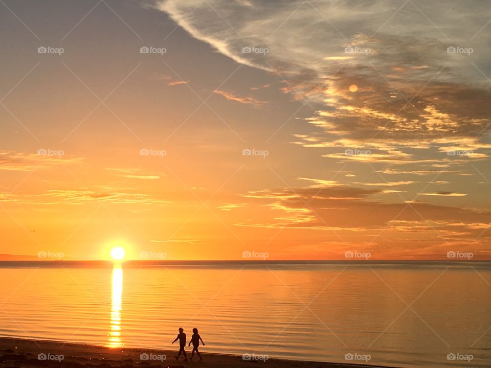 Romance at sunrise, couple walking toward the rising sun at dawn silhouette 