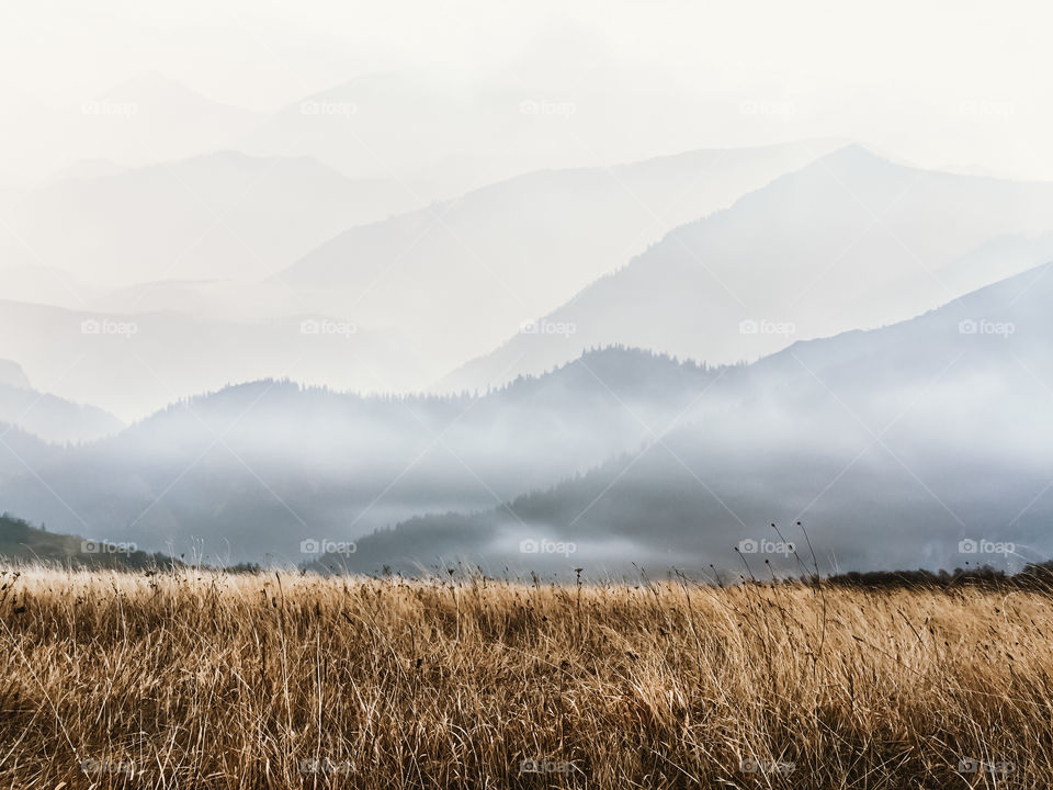 Scenic view of mountains against sky during foggy weather.