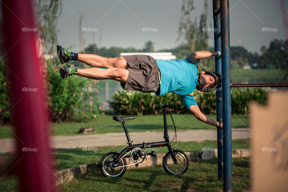 Man do human flag workout in the park