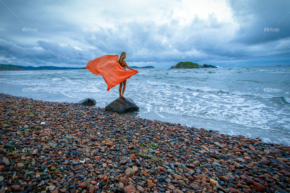 Young woman on the beautiful sea coast. Beautiful landscape, seascape.