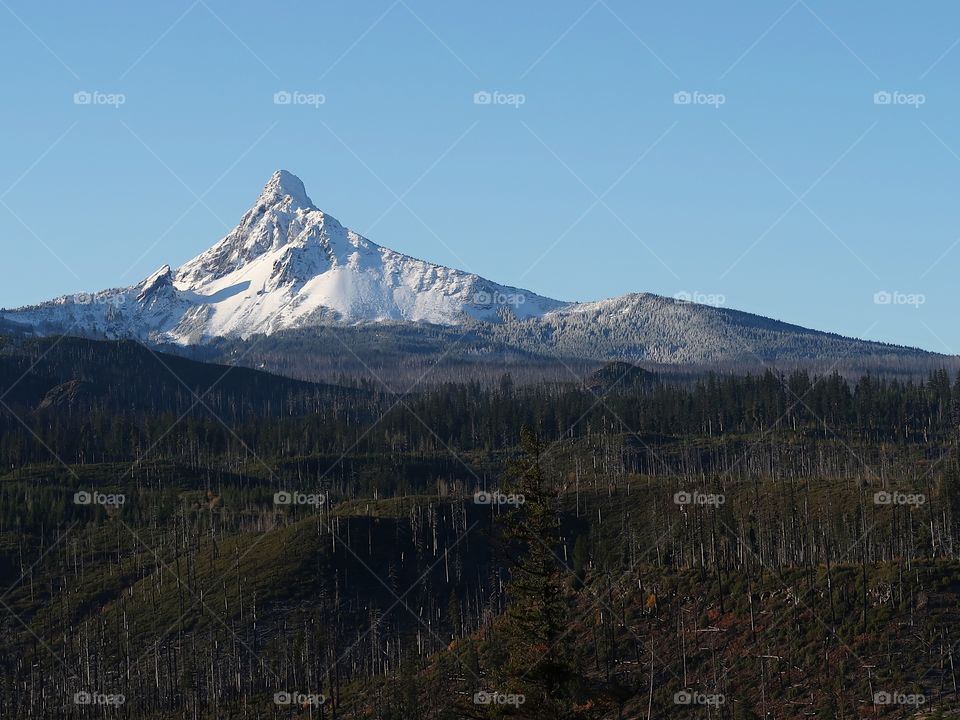 A fresh coat of snow covers the jagged peak of Mt. Washington in Oregon’s Cascade Mountain Range with clear blue skies on a cold winter morning.