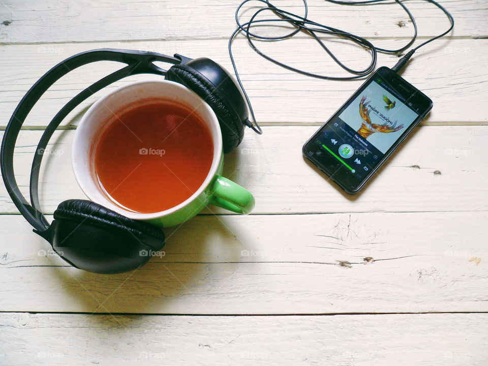 smart phone, headphones and a cup of tea on a white background