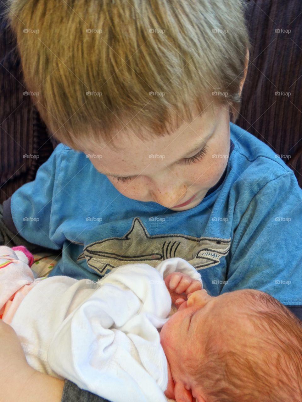 Boy Holding His Newborn Baby Sister
