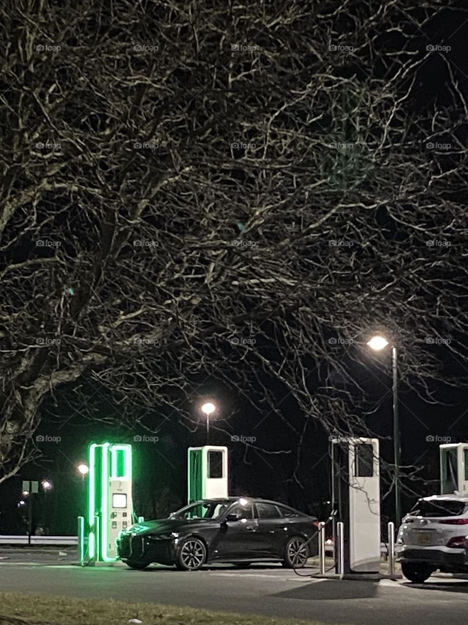 Electric cars being charged at charging stations at Freehold Raceway mall on a recent evening. Shot in Night mode on my iPhone 11.