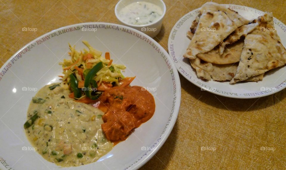 Indian food: vegetarian curry, vegetables, yogurt and naan