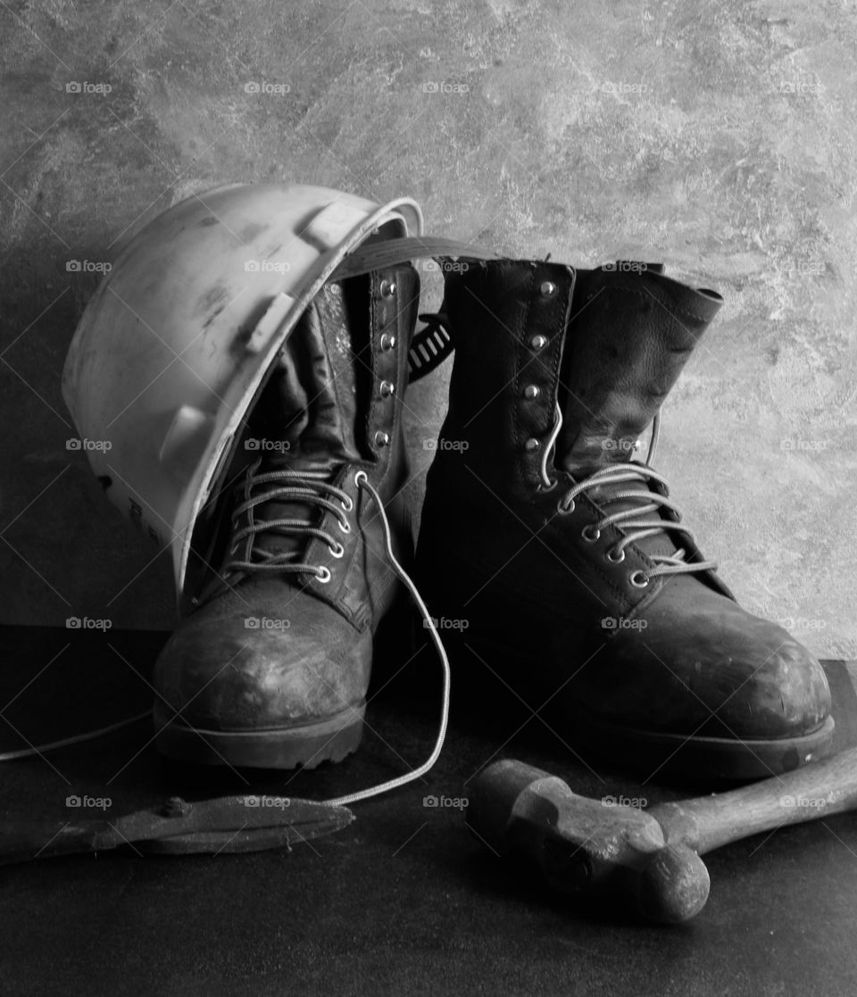 Still life of work boots work hat and tools