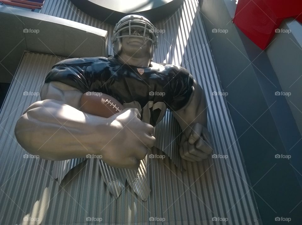 Football player statue carrying a football.