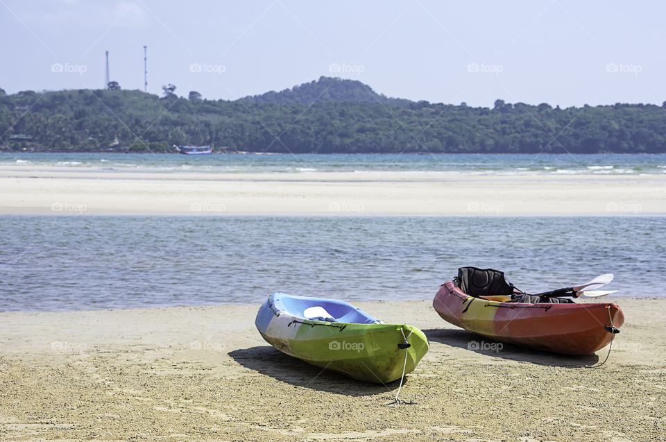 Kayaking on the sand of the sea background mountains and rocks.