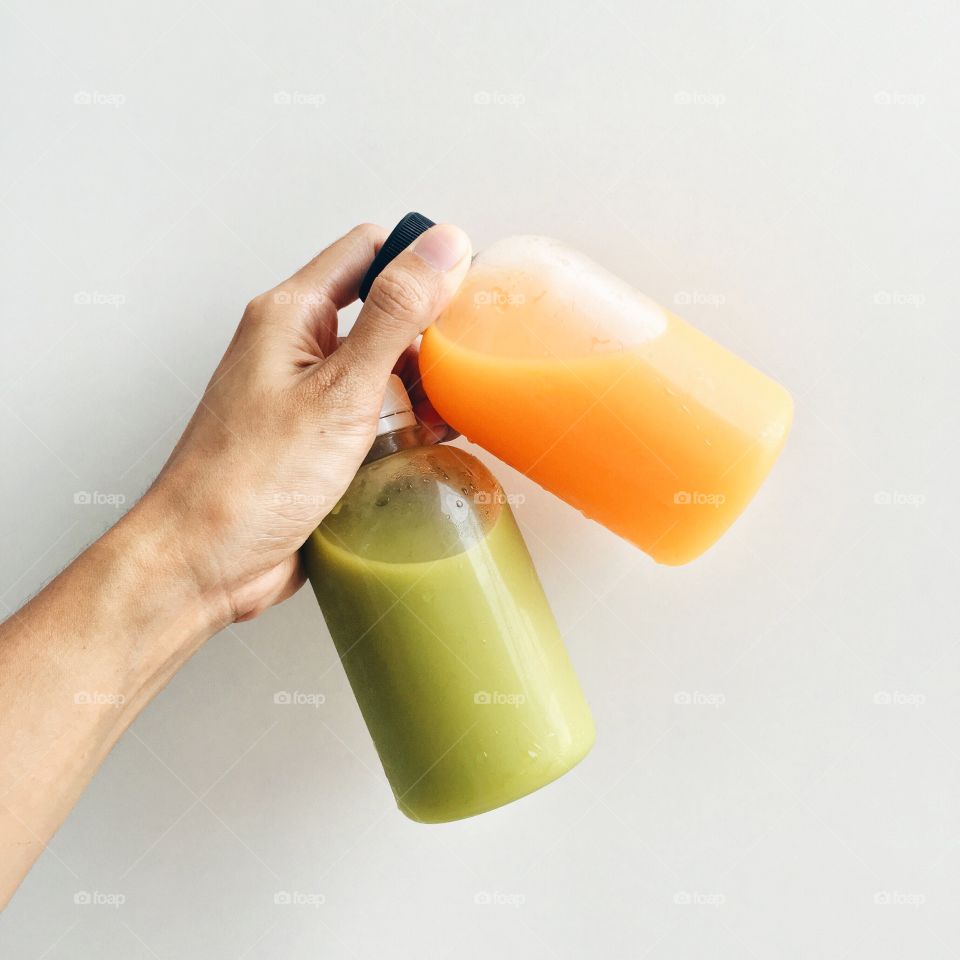 Holding food : Healthy drink with avocado juice and orange juice.