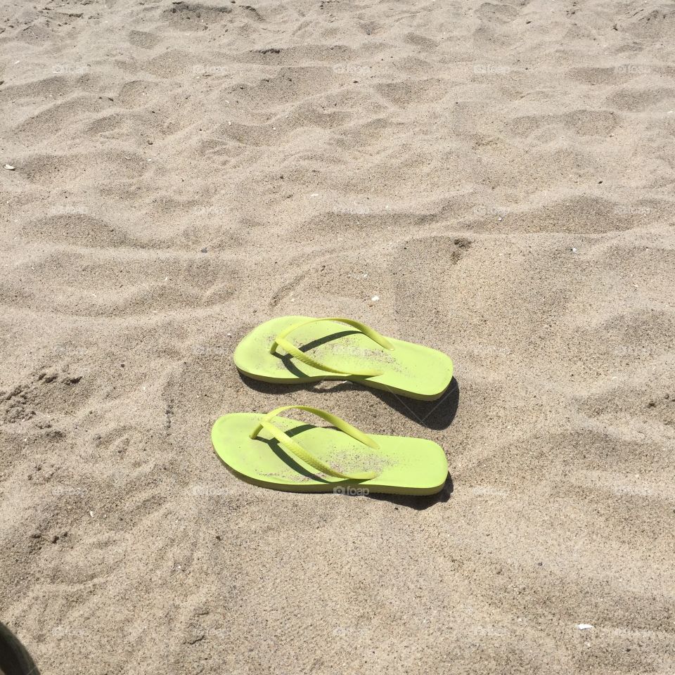 Green flip flops on the beach