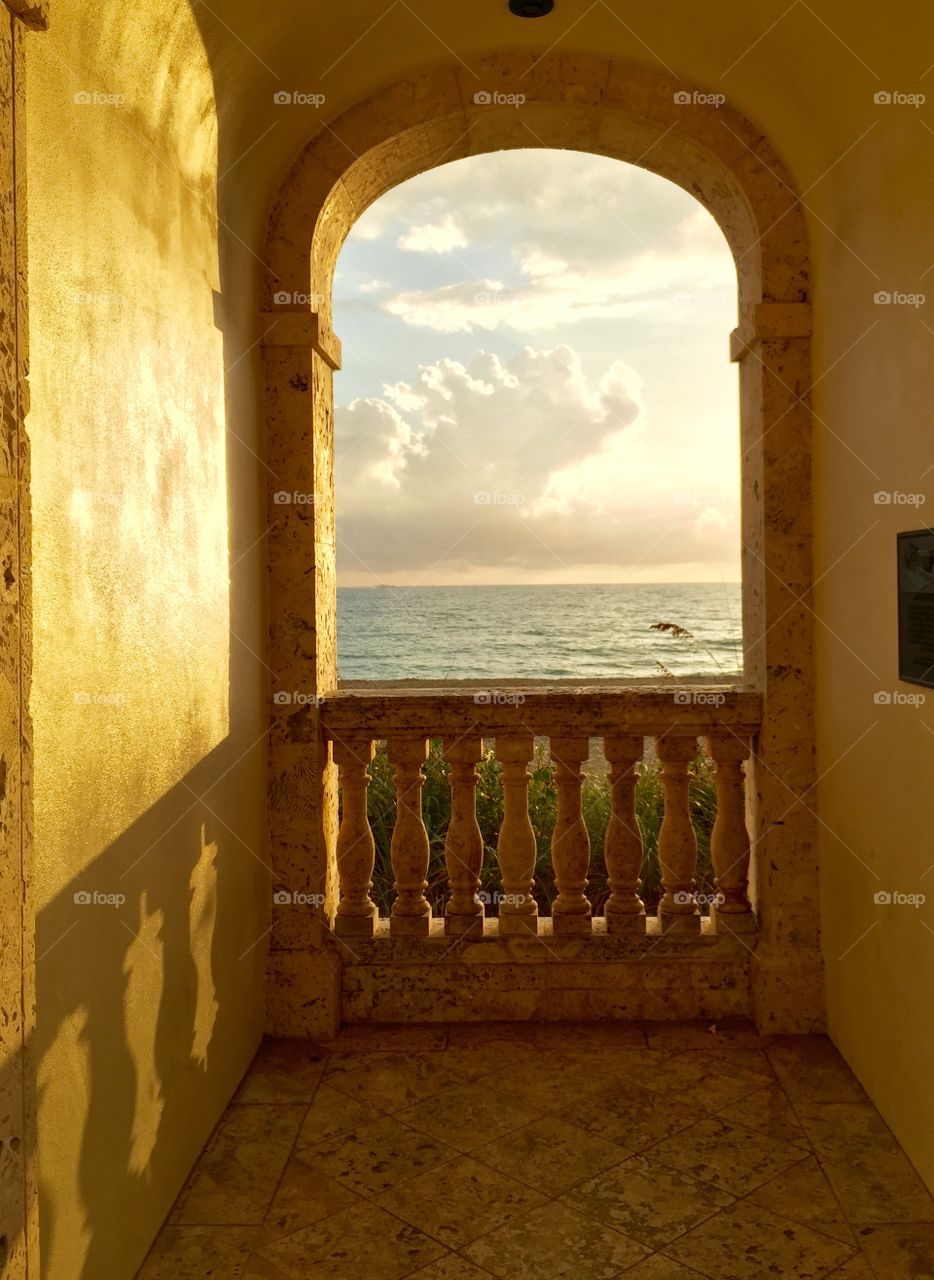 This is an old landmark on S Ocean Blvd I Palm Beach, FL as the sun rises, creating a shadow within the stone walls.