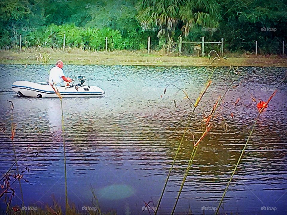 Man on the lake in a small boat. 