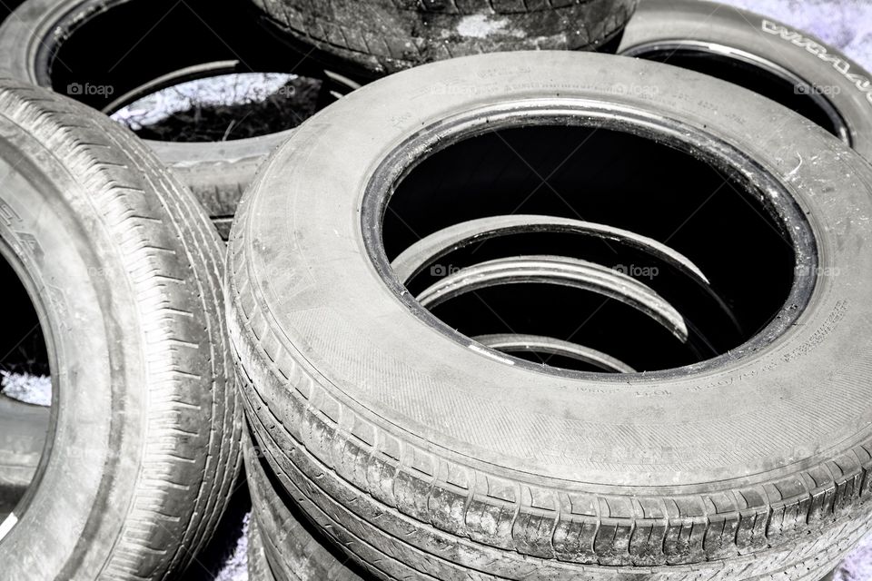 Background photo of used tires stacked on top of one another in closeup