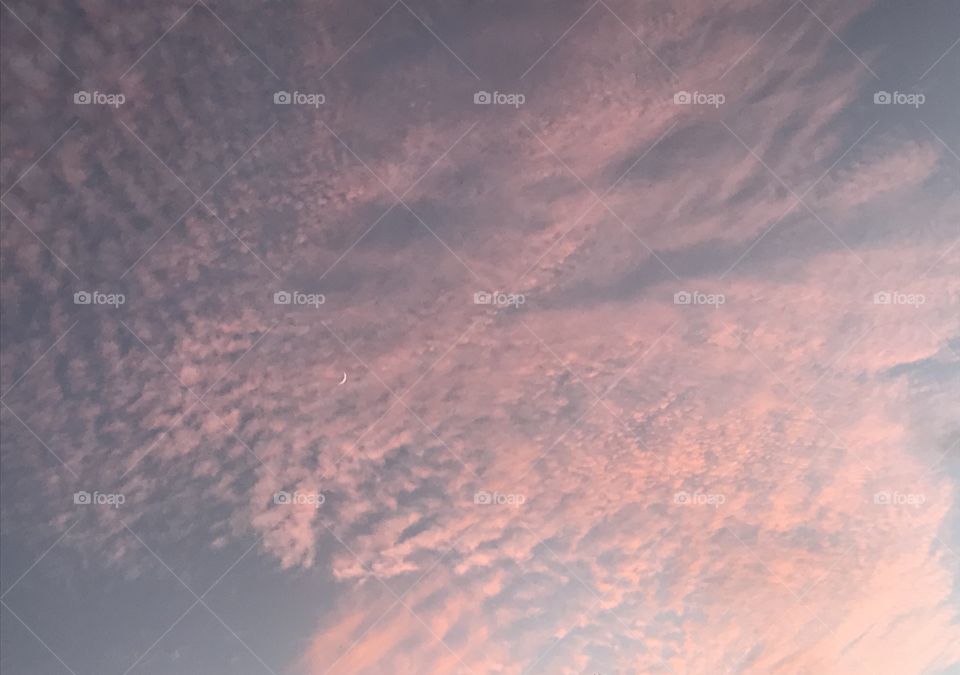 Sunset scattered clouds with the moon peeking through. Big Island Hawaii. 