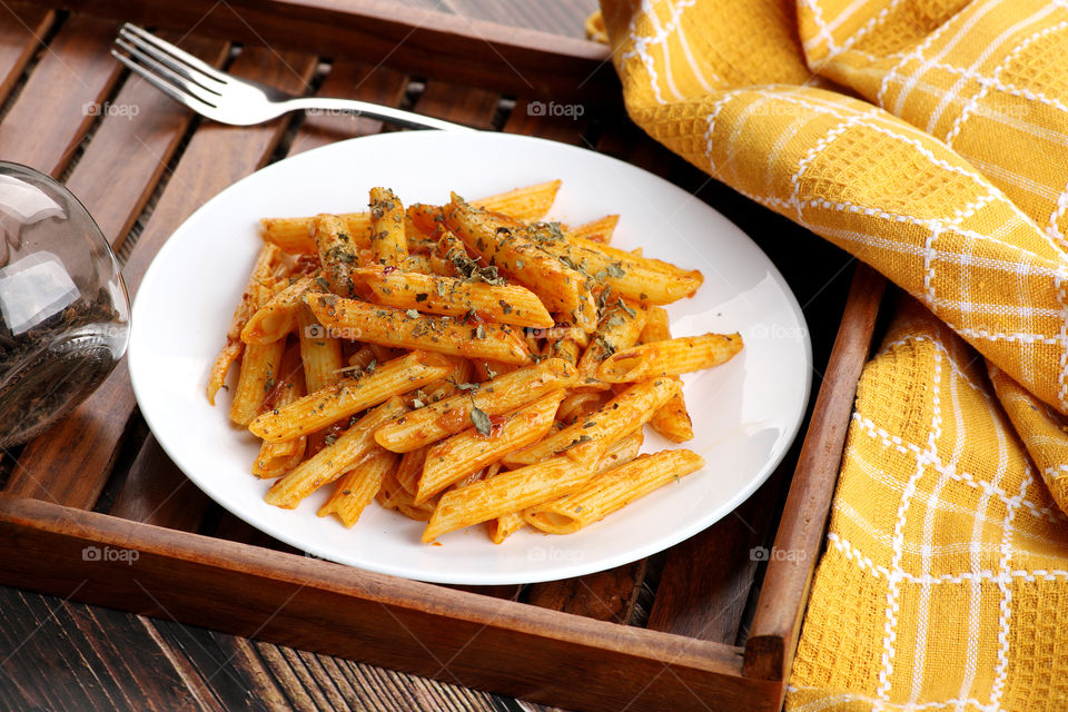 Penne Pasta food served in a wooden tray